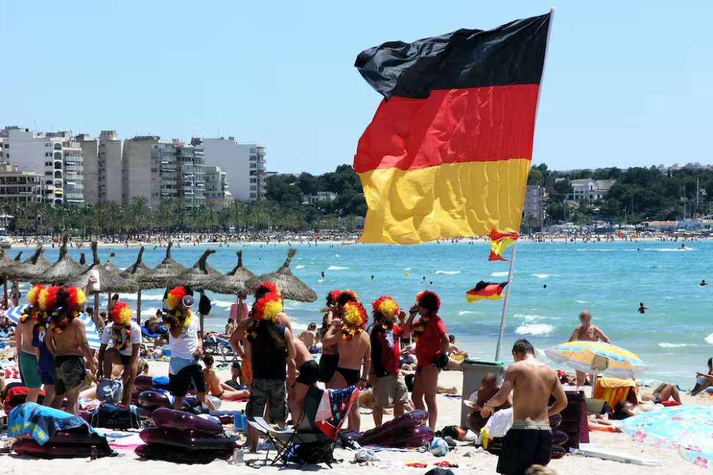 Germans relax on the beach of Mallorca with the national flag