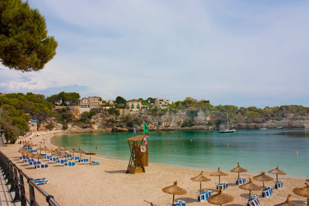 The beach in Porto Cristo is well-equipped with umbrellas and sun loungers