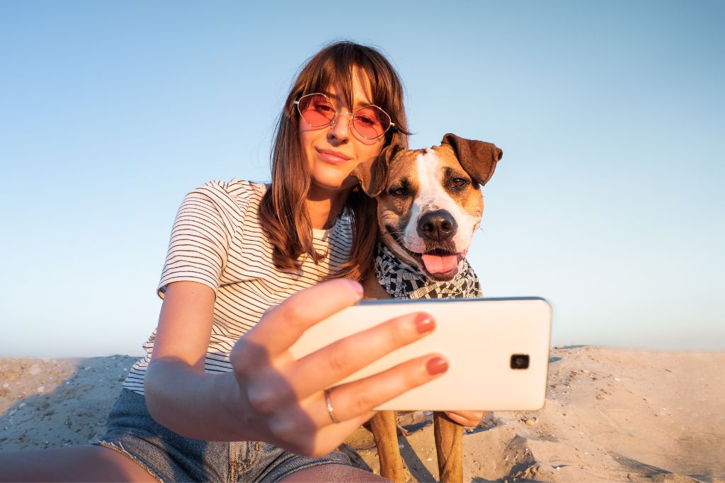 A girl and her dog are taking selfies