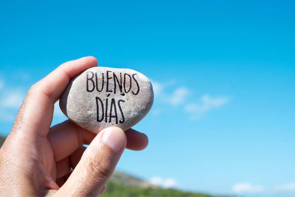 The inscription on the stone "Buenos días" (Good morning) in Spanish on the background of the sea