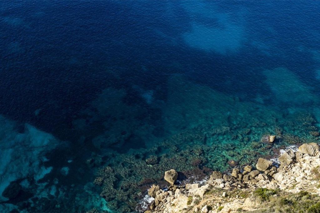 Clear blue sea and cliffs in Badia Grande