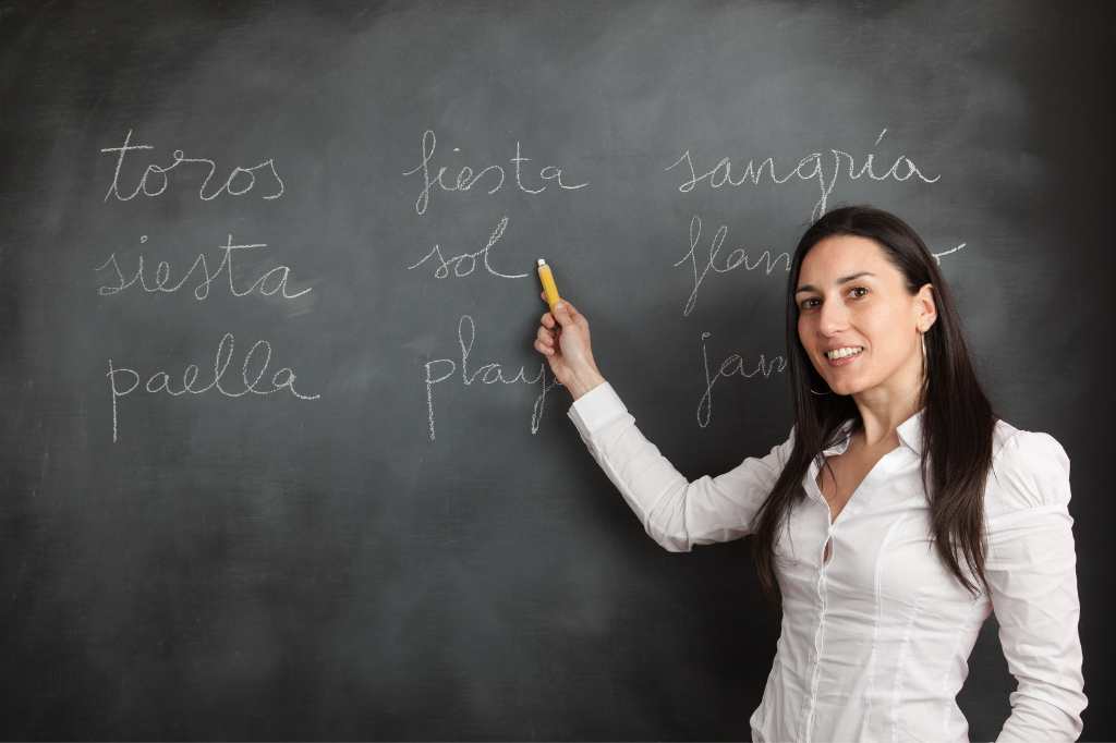 teacher writes words in Spanish on the board